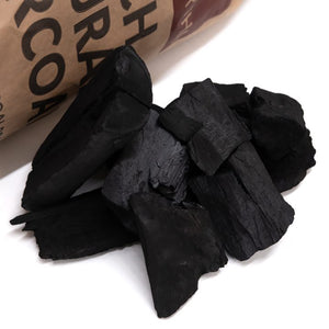 Kasai 10kg restaurant charcoal spilling from bag, featuring natural birch lumpwood ideal for outdoor BBQ and grilling use.