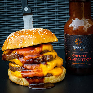 Juicy cheeseburger topped with Firefly's Competition Cherry BBQ Sauce, showcasing its rich, glossy texture and bold cherry flavor.
