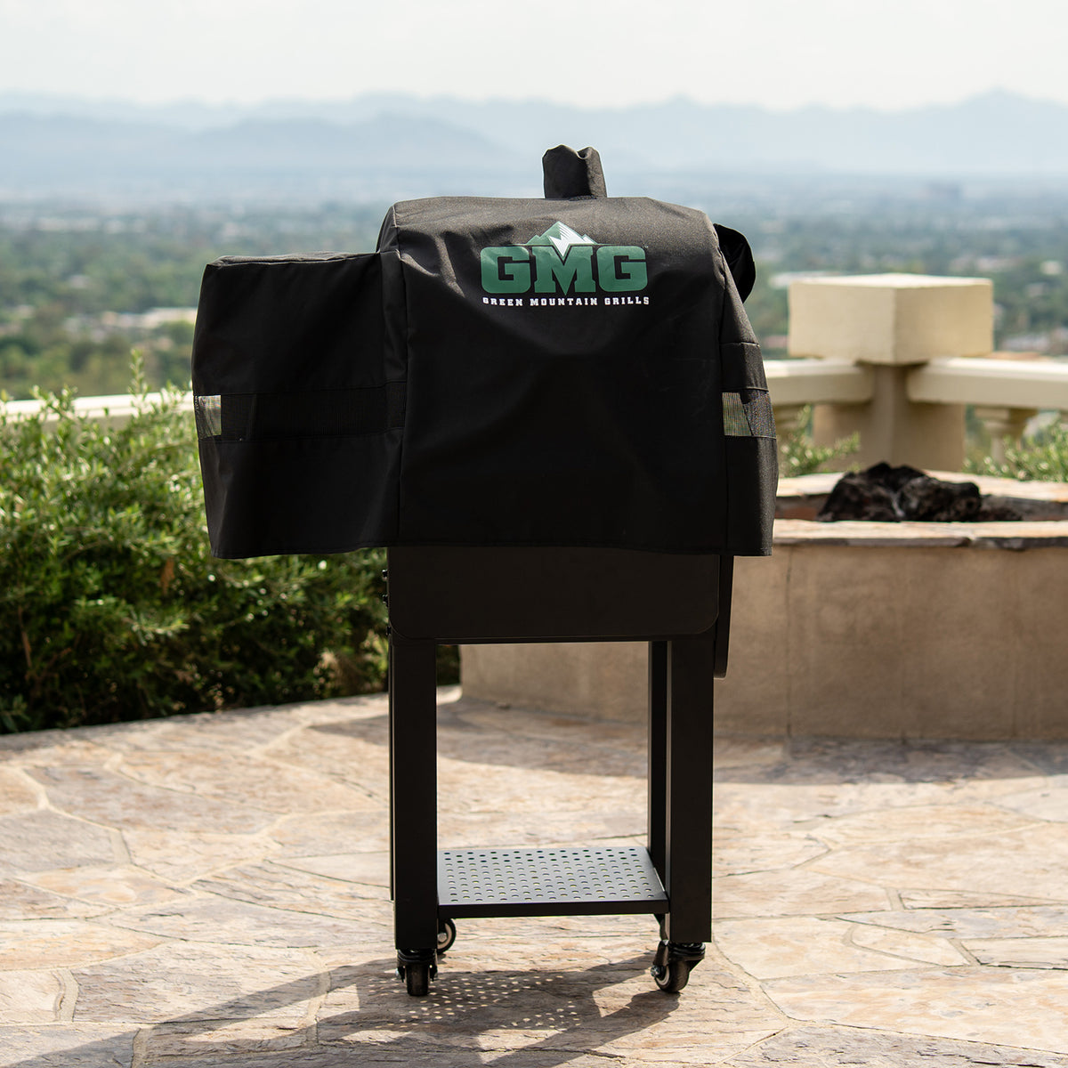 GMG grill cover on outdoor barbecue with scenic background