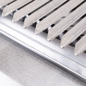 Close-up of stainless steel V-grate on the Bertha Asado Grill Small, designed for optimal heat distribution and grilling performance.