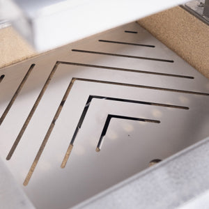 Interior view of the Bertha Asado Grill Small showing angled stainless steel fire grate for efficient airflow and heat control.