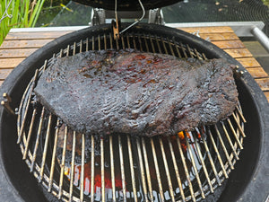 Bindaree Brisket - Grain-Fed BBQ on a grill, smoked to perfection with a charred crust, ideal for outdoor cooking.