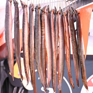 Smoked fish hanging from Borniak Double Smoking Hooks, showcasing their effectiveness in outdoor grilling and smoking setups.