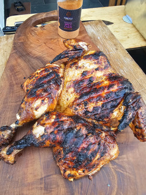 Grilled spatchcock chicken seasoned with Louisiana Spicy Cajun BBQ Rub on wooden board. Perfect for bold, smoky Cajun flavor.
