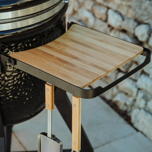 Close-up of Monolith TWO 66 Kamado Grill's bamboo side shelf with metal frame, emphasizing quality craftsmanship and functional outdoor grill design.