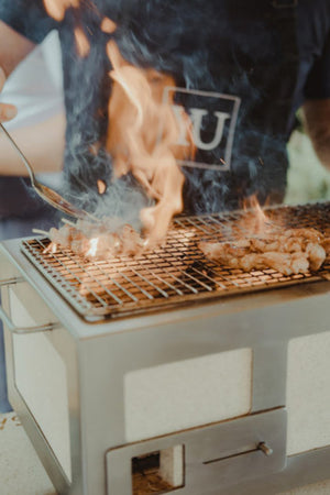 Grilling skewered meat over open flames on the Kasai Konro BBQ Grill with Steel Frame V2, perfect for authentic Japanese-style BBQ.