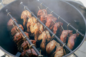 Interior view of Pit Barrel Cooker Prime Package - 22.5" PBX filled with hanging chicken and ribs, demonstrating large cooking capacity.