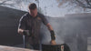 Man using Pit Barrel Stainless Steel Poultry Hanger - FireFly Barbecue to smoke poultry in a Pit Barrel Cooker for outdoor grilling.
