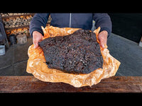 Person holding smoked meat in Borniak BBQ smoker