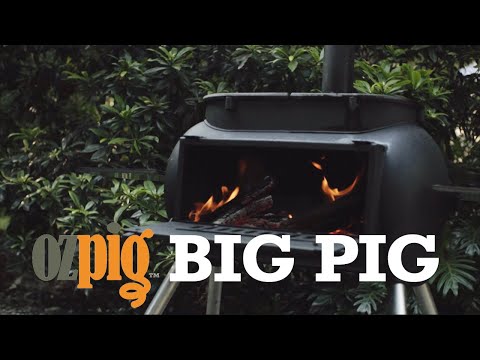 Ozpig Big Pig BBQ stove in use with firewood burning, highlighting its outdoor functionality for home or camping use.