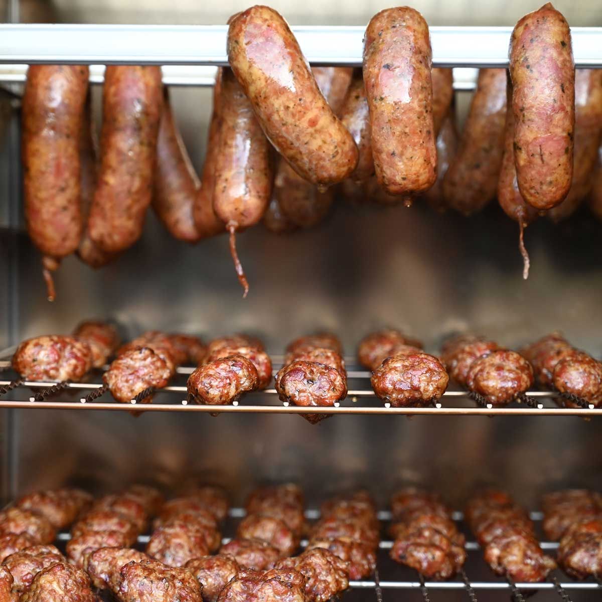 Cooked sausages on smoker grate in oven