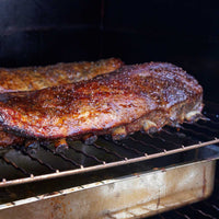 Cooking meat on a grill with a stainless steel Borniak smoker grate, high heat, outdoor barbecue