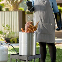 RAPICCA BBQ Gloves used for safely lifting turkey from deep fryer, ideal for outdoor cooking and grilling.
