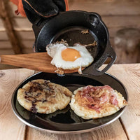 Petromax 30cm cast iron skillet with fried egg and breakfast items on black plate