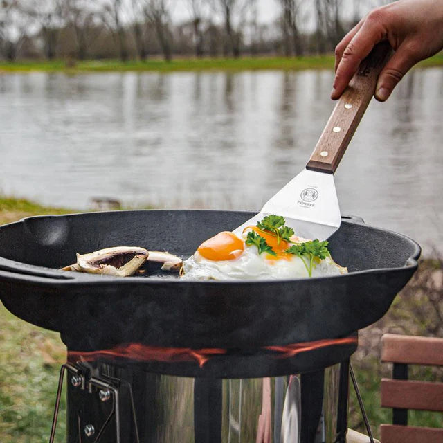 Petromax cast iron skillet with fried eggs and herbs outdoors