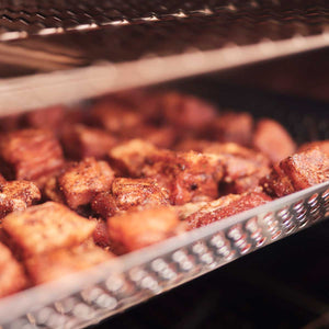 Borniak Smoker tray 150 - FireFly Barbecue filled with smoked meat cubes, showcasing its capacity and even heat distribution performance.