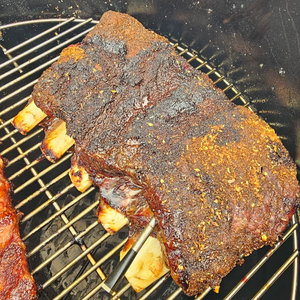 Beef ribs coated with Firefly BBQ Texas Spicy Rub on a grill, highlighting its smoky, bold TEX-MEX flavor. Ideal for BBQ and smoked meats.