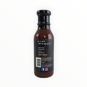 Waz's Sauce bottle with black cap on rustic wooden surface