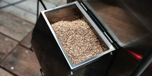 Top view of Borniak Smoke Generator Stainless Steel - FireFly Barbecue filled with wood chips, ready for use in outdoor smoking appliances.