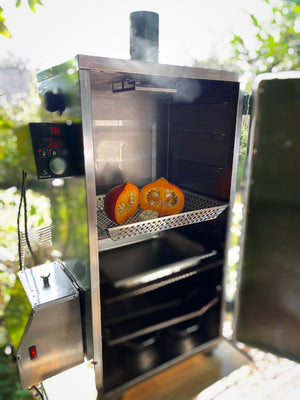 Borniak Smoker Tray 70 inside a smoker with pumpkin halves, demonstrating its use for smoking small foods in outdoor kitchen appliances.