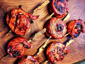 Grilled pork skewers glazed with California Apple BBQ Sauce, showcasing sweet and smoky caramelization on wooden board.