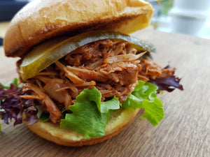 Pulled pork sandwich with lettuce and pickles, flavored with California Apple BBQ Sauce for a sweet, tangy bite without heat.
