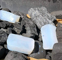 White solid fuel firelighters on black rocks for outdoor fire lighting