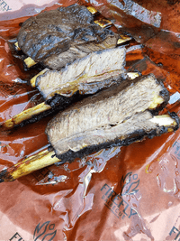 Beef ribs resting on OREN Pink Butchers Paper Roll - BBQ Meat Smoking | FDA Approved, demonstrating grease resistance and meat smoking efficiency.