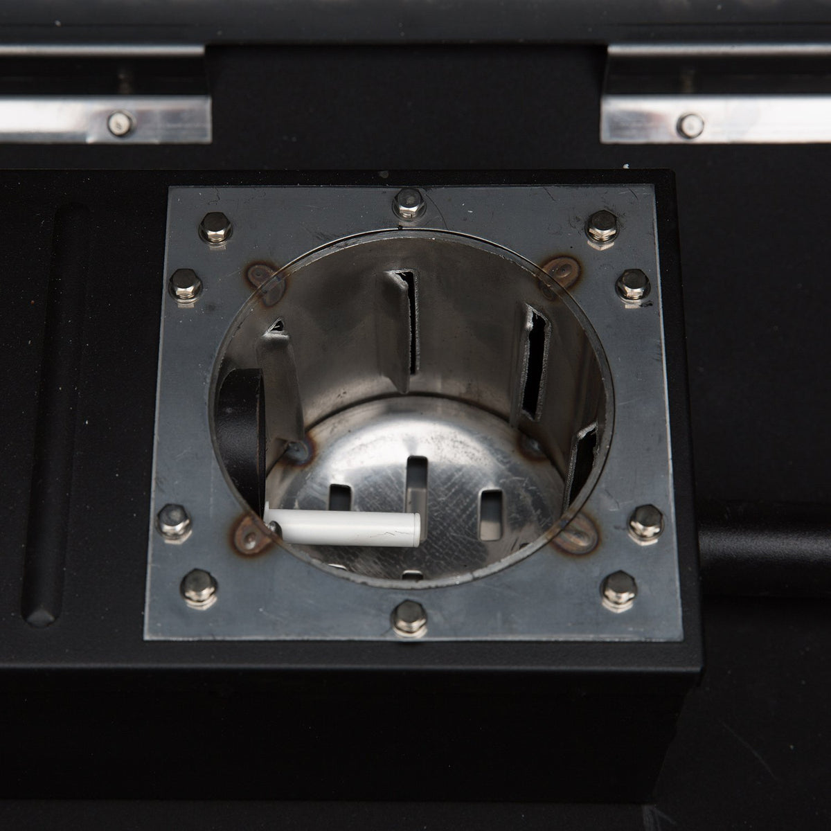 Burn pot of GMG PEAK Prime pellet grill with stainless steel construction for efficient heat distribution and ignition.