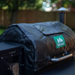 Angled view of GMG Thermal Blanket - FireFly Barbecue on a grill, highlighting its weather-resistant material and secure fit.