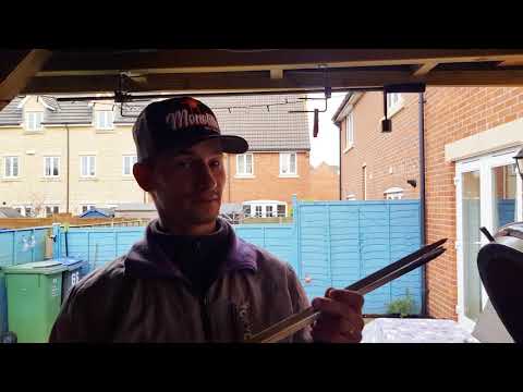 User holding Monolith LeChef Rotisserie skewers set, showcasing stainless steel skewers for use with outdoor ceramic grills.