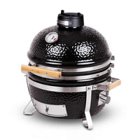 Side view of MONOLITH Icon Portable Kamado Grill showing textured ceramic body, stainless steel frame, and wooden handles for easy transport.