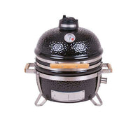 MONOLITH Icon Portable Kamado Grill with black ceramic dome, built-in thermometer, and wooden side handles for compact outdoor cooking.