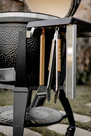 Close-up of Avantguard Classic grill's side shelf with hanging barbecue tools, highlighting its practical outdoor cooking design.