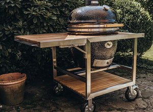 Monolith Le Chef Pro Series 2.0 Kamado Grill mounted in stainless steel cart with bamboo shelves, ideal for mobile outdoor kitchens.