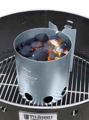 Pit Barrel Chimney Starter filled with lit charcoal briquettes on grill grate, ideal for consistent outdoor cooking performance.