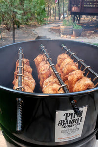 Pit Barrel PBX 22.5 Cooker with chicken skewers in outdoor garden setting