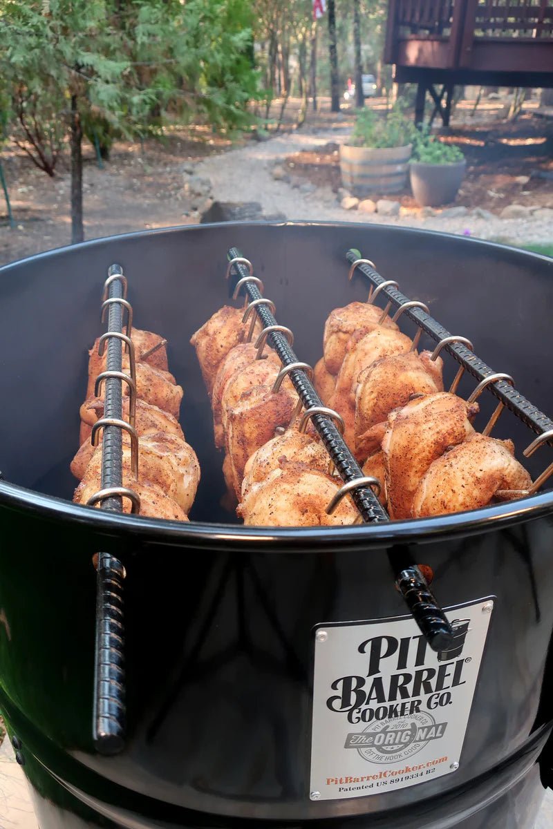 Pit Barrel PBX 22.5 Cooker with chicken skewers in outdoor garden setting