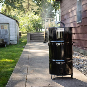 Pit Barrel Junior Standard Package - FireFly Barbecue set up outdoors, showcasing its compact size and portability for backyard grilling.