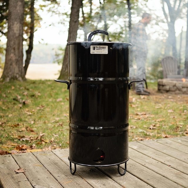 Pit Barrel Junior smoker outdoor setup with trees and grass