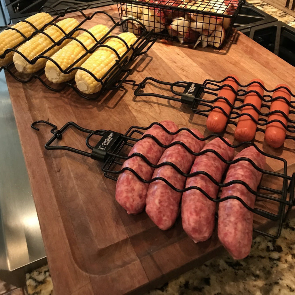 Pit Barrel Sausage, Hot Dog & Brat Hanger - FireFly Barbecue loaded with hot dogs, brats, and corn on a wooden prep surface.