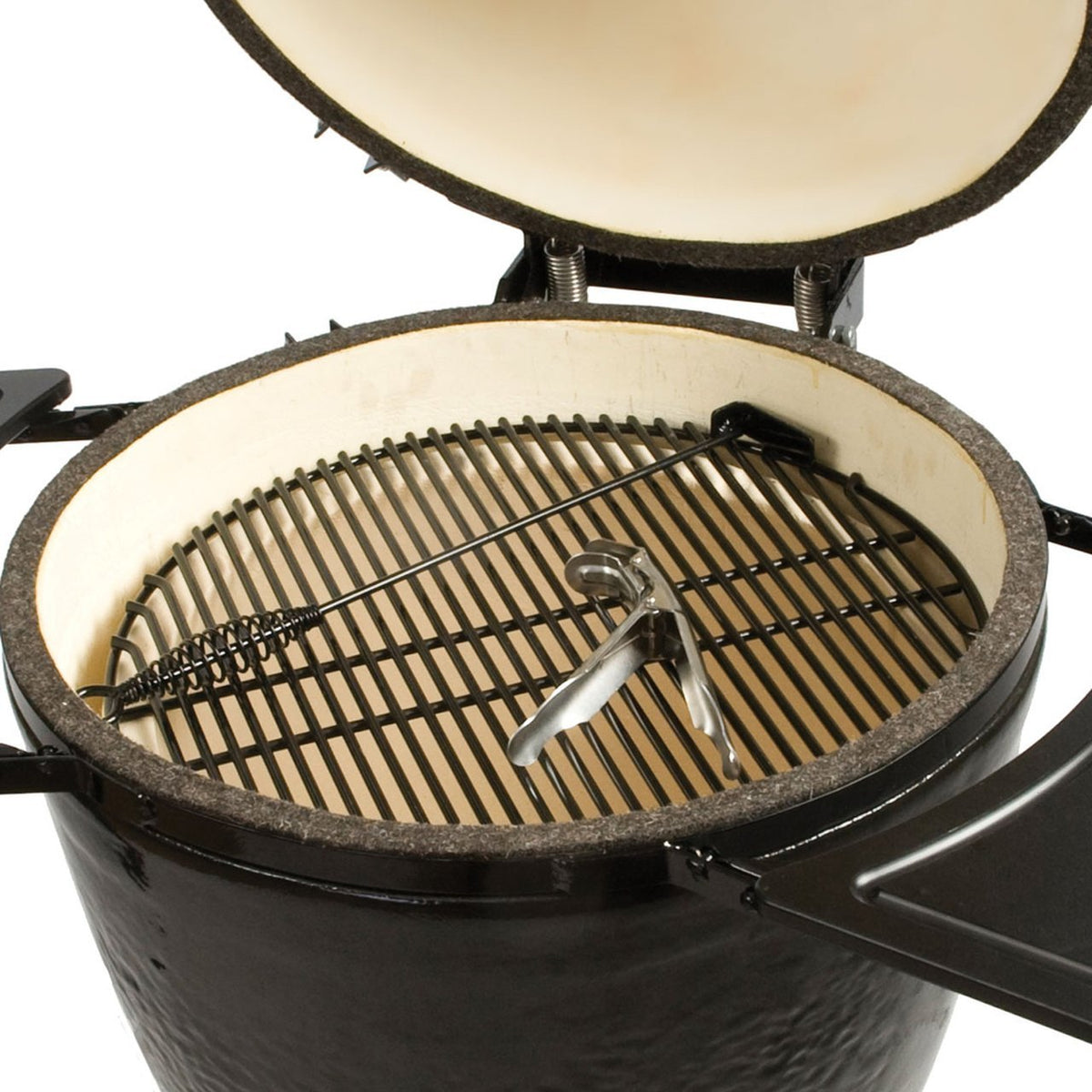 Interior view of Primo Kamado BBQ Grill showing ceramic firebox, stainless steel grates, and included grilling tools for premium cooking.