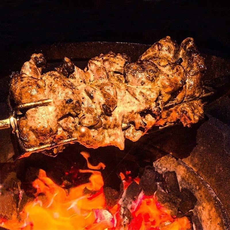 Rotisserie chicken roasting on BBQ with Primo Rotisserie Kit