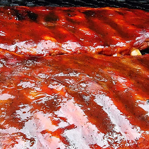 Grilled ribs glazed with Sweet Texas BBQ Sauce by Firefly, showcasing a rich, glossy finish perfect for enhancing BBQ dishes with sweet tangy flavor.